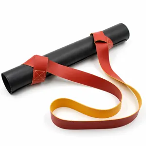 Portable leather yoga mat strap harness, black rolled mat with red yellow carrying belt.
