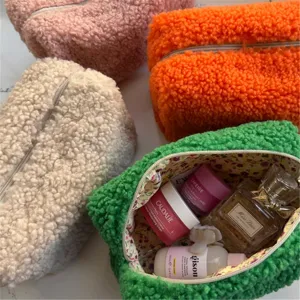 Detailed shot of fluffy teddy fleece cosmetic bag with floral lining and roomy interior storage.