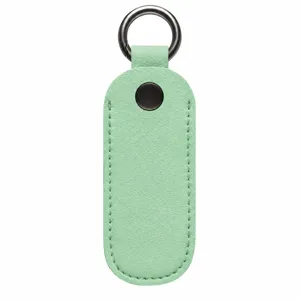 Vista detallada de la funda protectora de cuero para memoria USB con llavero y botón metálico.
