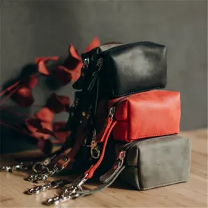 Close-up detail of multi-color leather dog waste bag holder with metal hardware and strap.