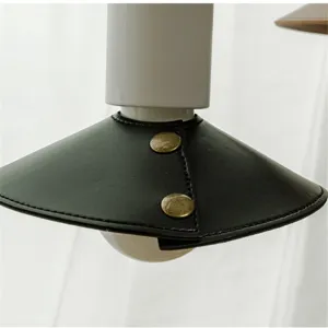 Close-up detail of outdoor camping leather lampshade with vintage brass snap buttons.