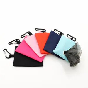 Colorful canvas dog waste bag holder detail showing portable pet poop bag dispenser with hook.