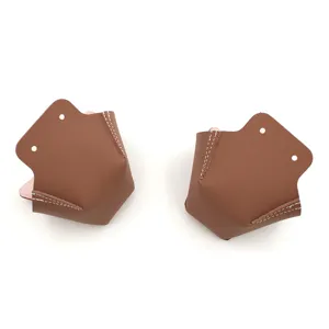 Primer plano de protectores de puntera de patines de cuero marrón con costuras blancas y agujeros.