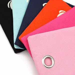 Canvas dog waste bag detail showing vibrant multi-color fabric variants with metal grommets.