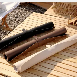 Rolled leather picnic mat and outdoor desk pad detail showing black, brown and beige colors.