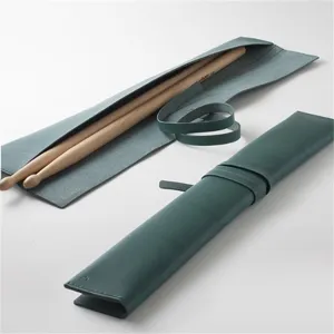 Dunkelgrüne Leder Trommelstock Rolltasche mit sicherem Riemen und Holztrommelstöcken.