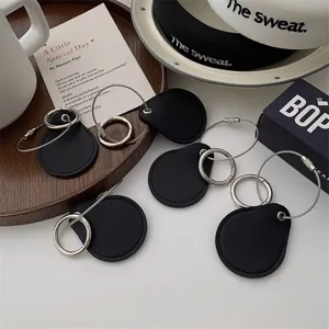 Llavero de cuero negro en forma de gota con anillo de alambre metálico para uso diario.