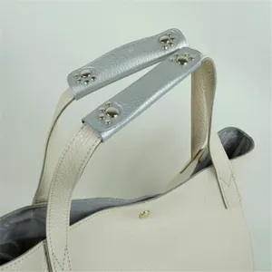 Close-up of detachable leather bag handle wrap with silver paw studs for comfortable grip.