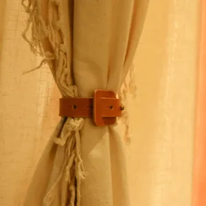 Close-up detail of brown PU leather curtain tieback strap, durable and elegant home decor.
