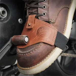 Detaillierte Nahaufnahme des braunen Leder Motorrad Schalthebel Stiefelschutzes mit Gurt.