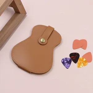 Guitar pick case detail showing brown leather pouch and colorful guitar picks close-up.