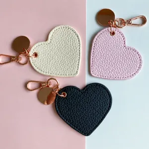 Portachiavi in ecopelle PU a forma di cuore con parti in oro rosa in bianco, rosa e nero.