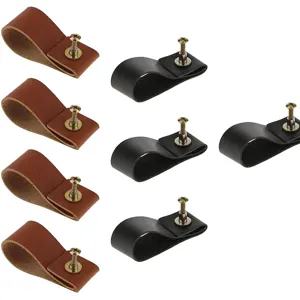 Leather cabinet pulls with gold screws, vintage drawer knobs for furniture detail view.