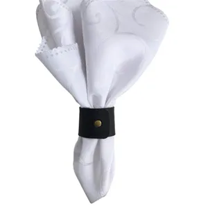 Anello portatovagliolo in pelle PU nera con elegante tovagliolo in tessuto di pizzo bianco.