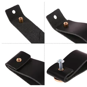 Close-up detail view of black leather cabinet drawer pull handle with brass insert and screw.