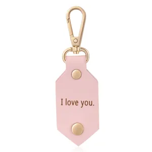 Pink leather keychain with gold metal clasp and engraved I love you text detail view.