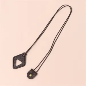 Detail of brown leather sunglasses strap with triangle pendant and metal snap button design.
