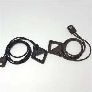 Detailed shot of leather sunglasses lanyard with triangular cutout design and metal snap button.