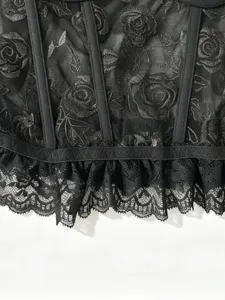 Dettaglio in primo piano del corsetto di pizzo nero trasparente con ricamo di rose.