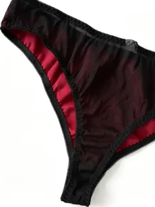 Gothische spitze netz lingerie slip detailansicht, elegantes schwarz und rot kontrast design.