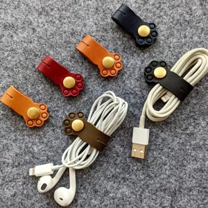 Detailed view of cute cat paw leather cable organizers and cord winders in various colors.