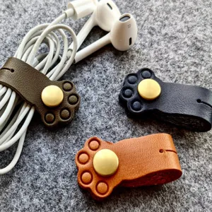 Leather cat paw cable winder detail view, cute cord organizer for earphones and data lines.