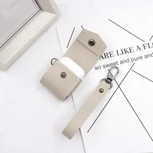 Beige PU leather AirPods case with hand strap and metal snap button for wireless earphones
