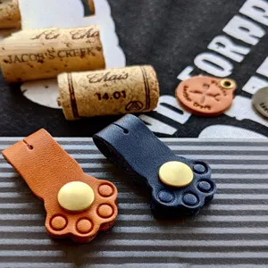 Cute cat paw cord organizer, leather cable winder with snap button for headphones and data lines.