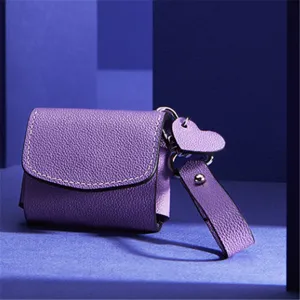 Close-up of purple PU leather wireless earphone case featuring a cute heart charm.