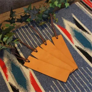 Detail shot of vintage PU leather bookmarks with cord on textured blanket. Close-up view.