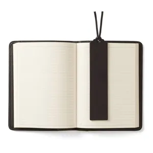 Detail view of vintage brown PU leather notebook and matching bookmark with lined pages.