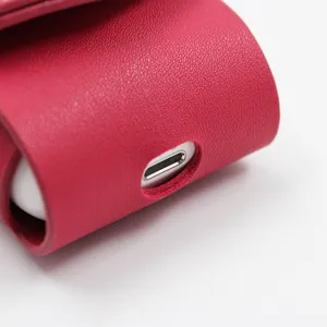 Close-up detail shot of the vibrant pink PU leather wireless earphone case charging port.