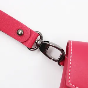 Close up detail of pink PU leather headphone case strap with metal lobster clasp and rivets.