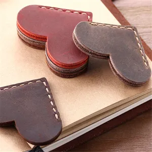 Close-up detail of handmade vintage crazy horse leather heart bookmark with neat stitching.