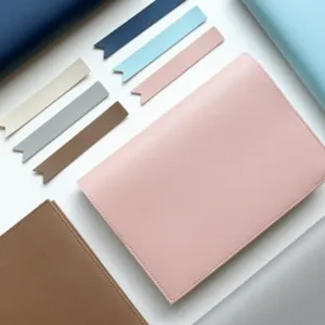 Detail view of minimalist PU leather notebook cover with colorful bookmark strips, flat lay style.