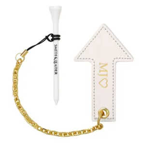 Golf tee holder set featuring a white tee and leather arrow charm connected with a gold chain.