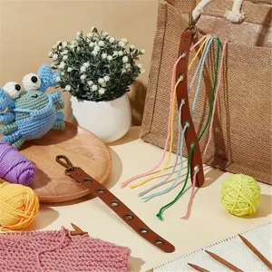 Organisateur de fil en cuir portable detail avec oeillets et fils colores en atelier.