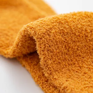 Soft coral fleece fabric detail of cozy fuzzy winter socks, warm and comfortable texture.
