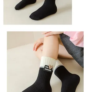 Girls black white long socks knee high school style cute heart badge detailed view soft knit