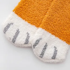 Close-up of cozy coral fleece cat paw socks, soft plush warm winter sleep floor socks.