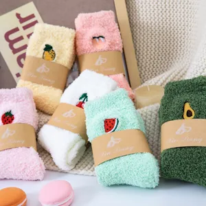 Close-up detail of cute winter fuzzy coral fleece socks with sweet fruit embroidery designs.