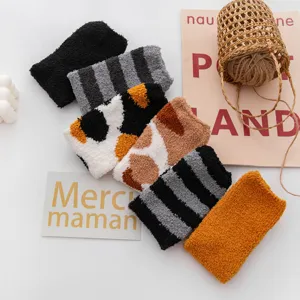 Close-up detail shot of cozy thick coral fleece fuzzy socks in various cute patterns and colors.