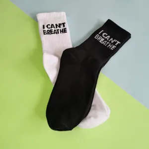 Black and white mid-calf cotton socks with letter print, casual daily wear apparel product.