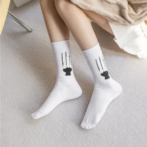 Close-up detail of cute white mid-calf socks featuring funny black cat claw scratch graphic.