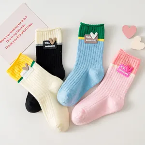 Cute college style contrast color crew socks with heart patch, soft cotton material.