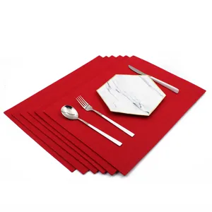 Red square felt placemat set with marble pattern plate and cutlery for table decor.