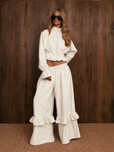 Detail view of the elegant beige two piece outfit featuring zip top and wide leg pants.
