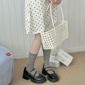 Detailansicht von grauen Wadensocken für Damen, kombiniert mit schwarzen Mary Jane Schuhen.