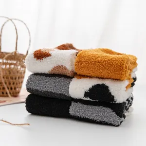Cozy fuzzy coral fleece winter warm sleep socks stacked on table for women home wear