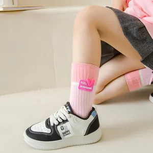 Girls pink long cotton stack socks with heart soft label, sweet Korean style daily wear.